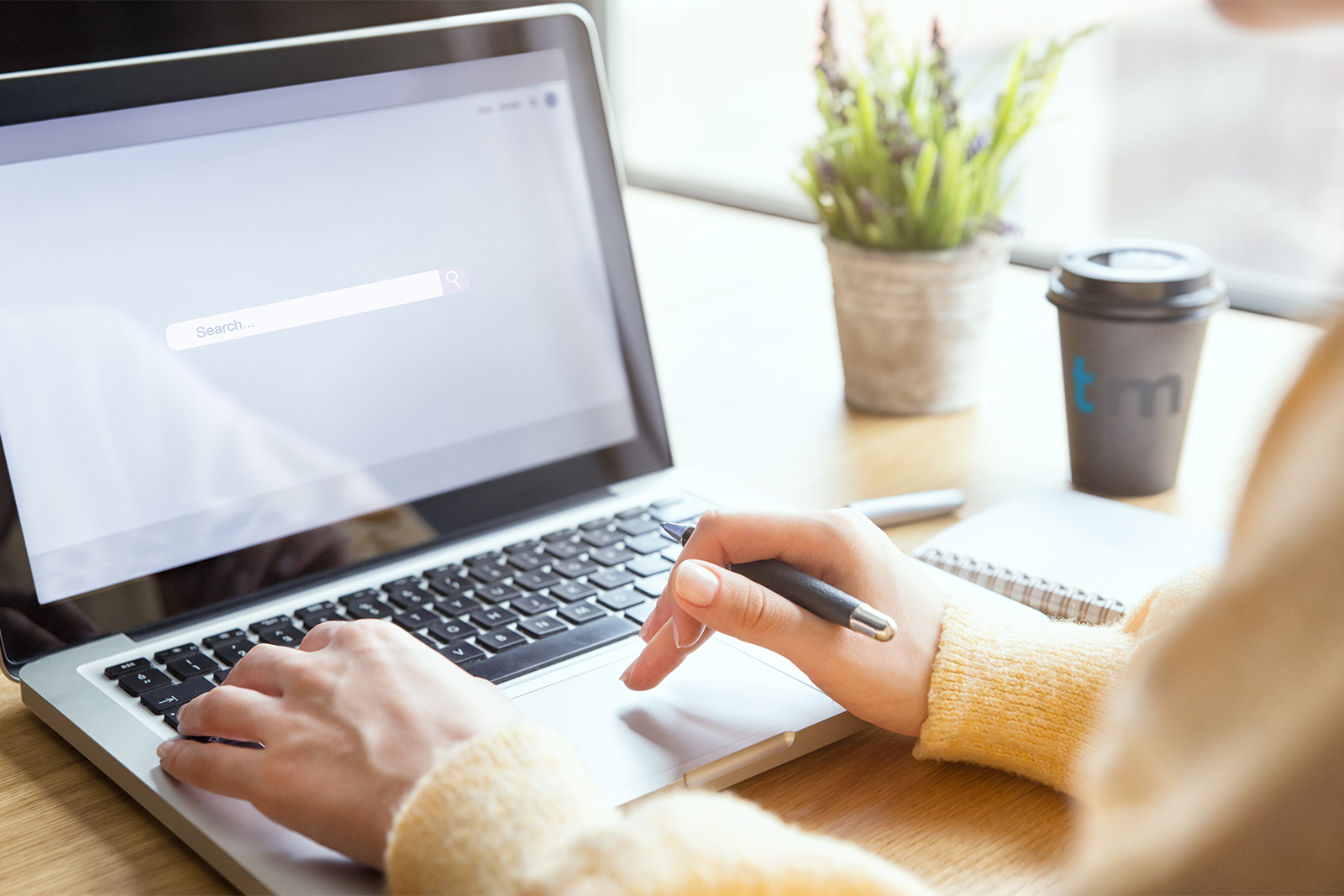 Photograph of a person using a search engine on a laptop.