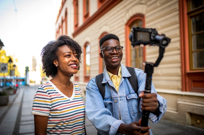 Charming young people making video blog at the city street